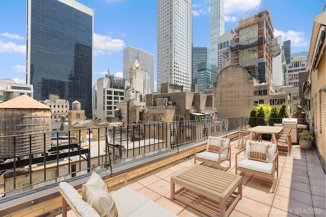 view of patio with a city view, a balcony, and an outdoor hangout area