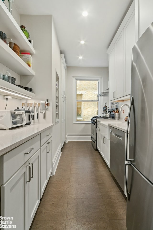 kitchen featuring white cabinets, recessed lighting, baseboards, and stainless steel appliances