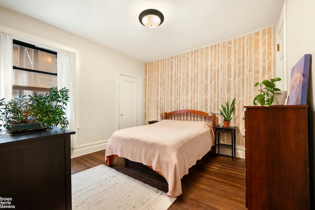 bedroom with dark wood finished floors and baseboards