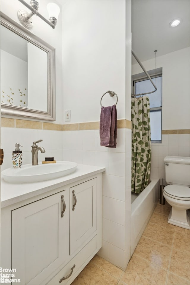 full bath with toilet, vanity, tile walls, and tile patterned floors