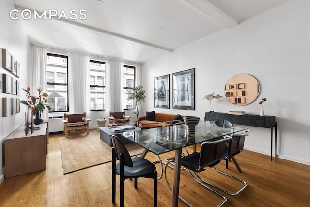 dining room with radiator heating unit, wood finished floors, beam ceiling, and baseboards