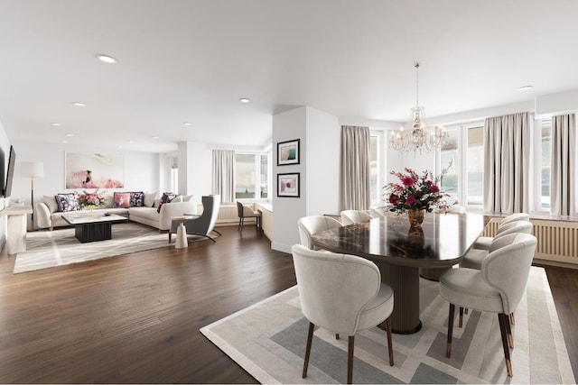 dining space with dark hardwood / wood-style flooring and an inviting chandelier