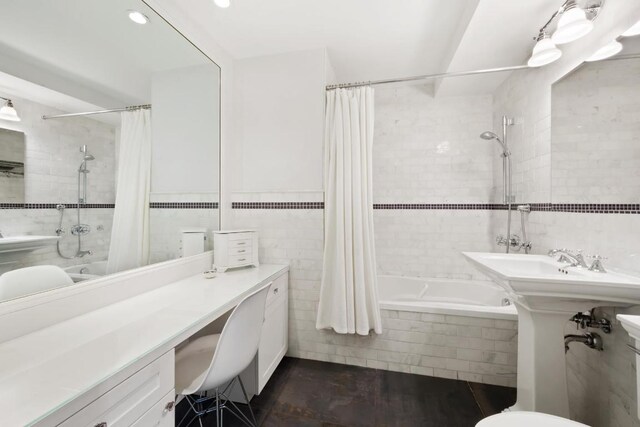 bathroom with tile walls and shower / bath combo with shower curtain