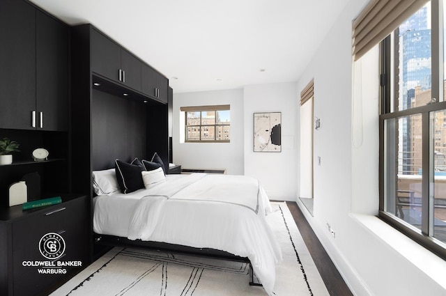 bedroom with dark hardwood / wood-style flooring