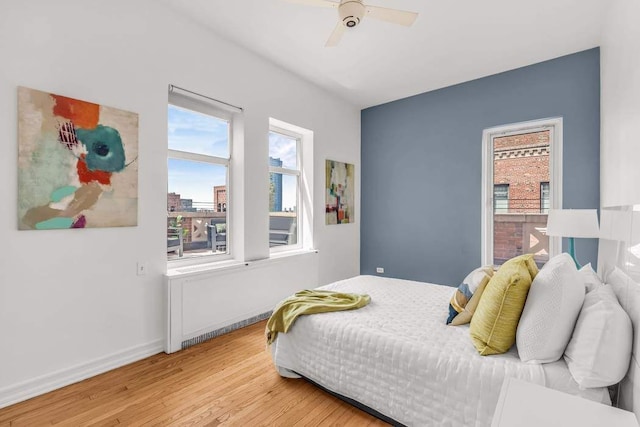 bedroom featuring light wood finished floors, a ceiling fan, and baseboards