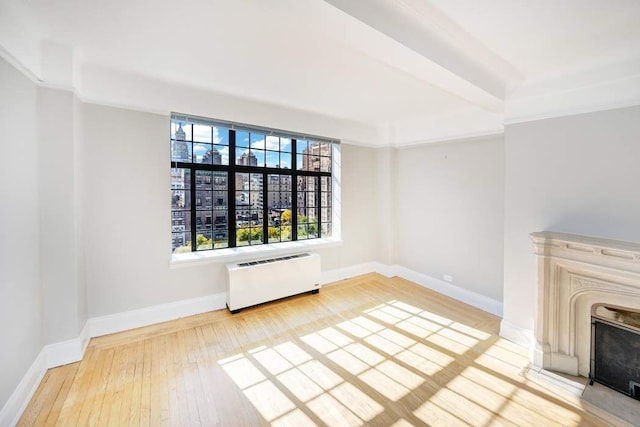 unfurnished living room with radiator heating unit and hardwood / wood-style floors