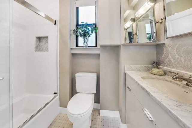 full bathroom with vanity, enclosed tub / shower combo, and toilet