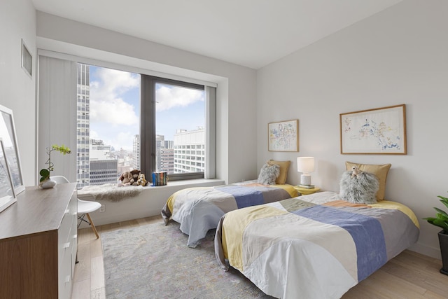 75 Wall St Unit 34M, New York City, NY 10005 - bedroom featuring multiple windows, a city view, and wood finished floors