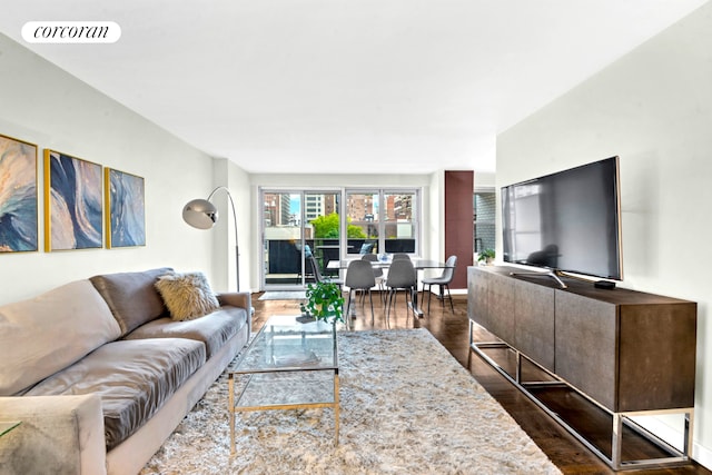 living area with visible vents, baseboards, and wood finished floors