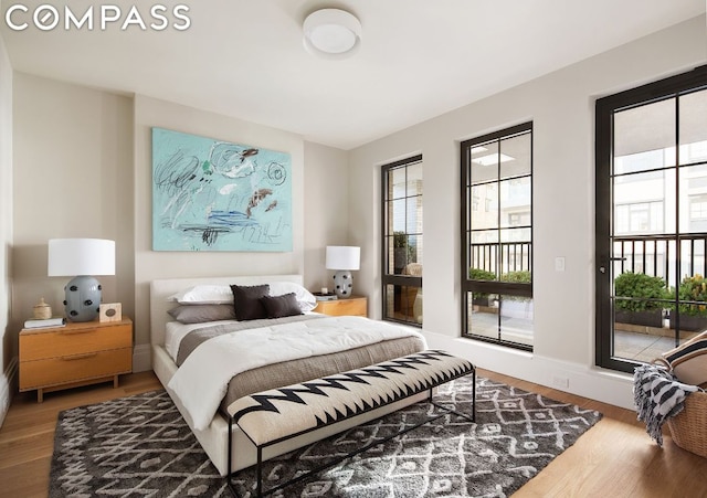 bedroom featuring hardwood / wood-style floors and access to outside