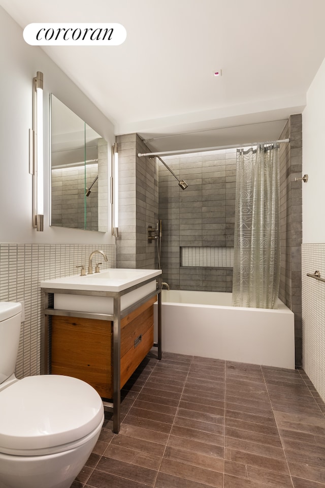 bathroom featuring shower / bath combination with curtain, tile walls, toilet, and vanity