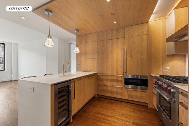 kitchen with wine cooler, stainless steel appliances, a peninsula, a sink, and visible vents