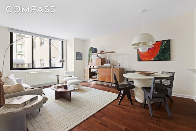 living area with baseboards and dark wood-style flooring