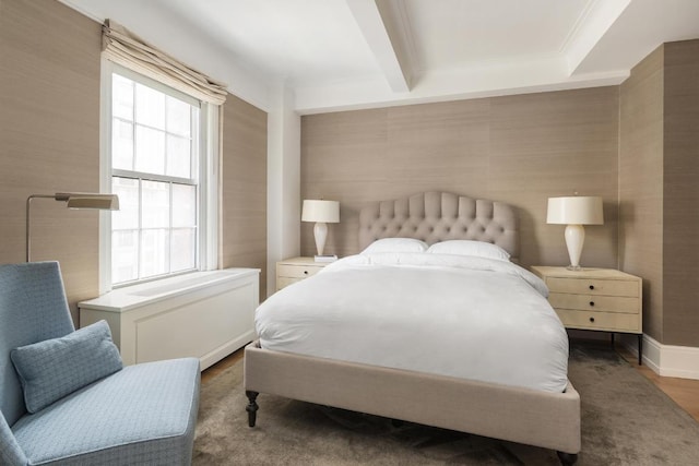 bedroom with beamed ceiling, hardwood / wood-style floors, and multiple windows