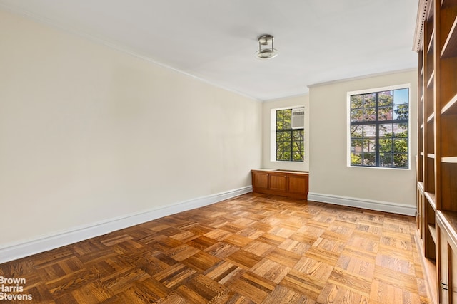 empty room featuring baseboards and crown molding