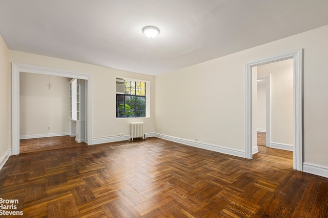 unfurnished bedroom featuring radiator and baseboards