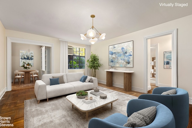 living area featuring a chandelier and baseboards