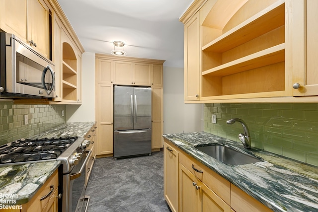 kitchen with open shelves, dark stone counters, stainless steel appliances, and a sink