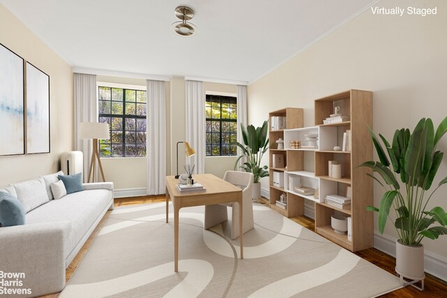 office area with light wood finished floors, baseboards, and ornamental molding