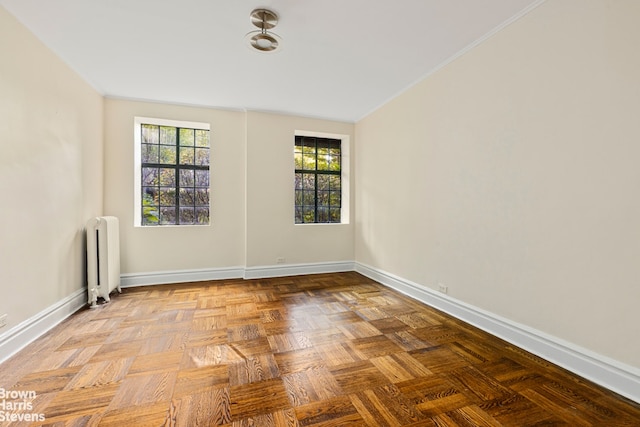 spare room featuring radiator and baseboards