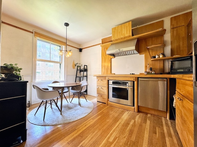 kitchen featuring ventilation hood, light wood-type flooring, oven, hanging light fixtures, and an inviting chandelier