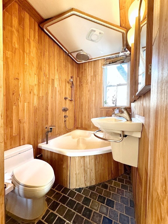 bathroom with shower / bath combination, toilet, and wood walls