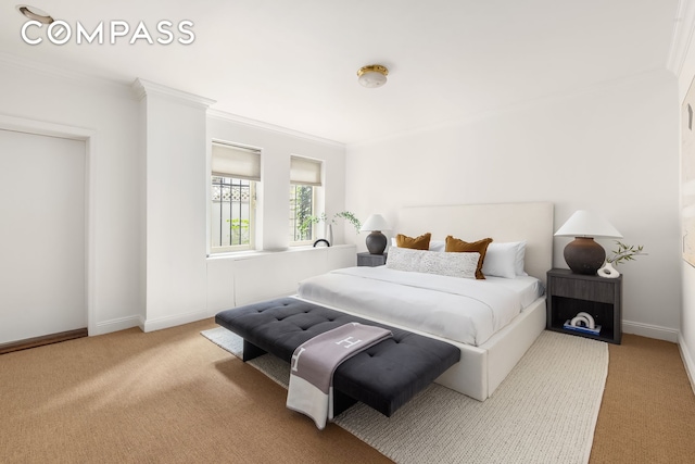 carpeted bedroom with ornamental molding and baseboards