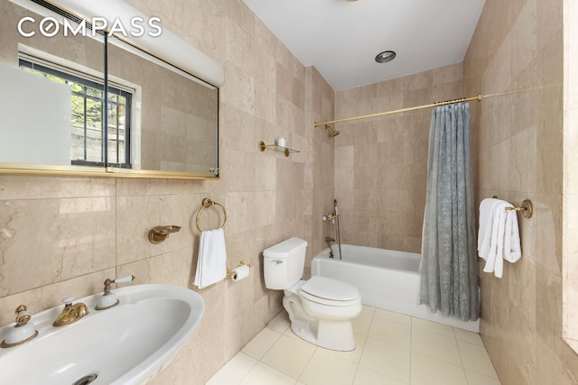 bathroom with toilet, a sink, tile walls, tile patterned floors, and shower / bath combo with shower curtain