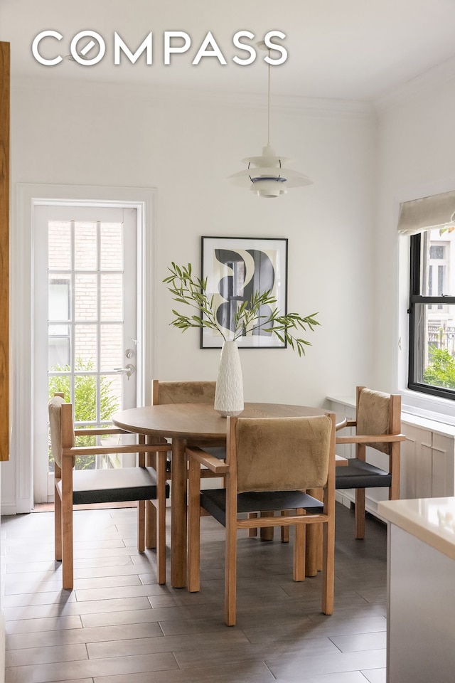 dining space with crown molding and light wood finished floors