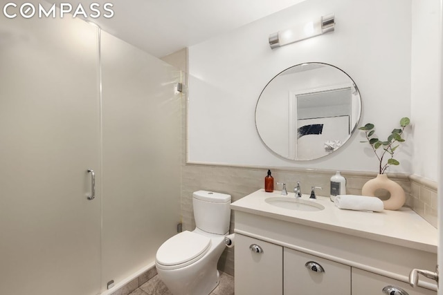 bathroom featuring tile walls, vanity, tile patterned flooring, and toilet