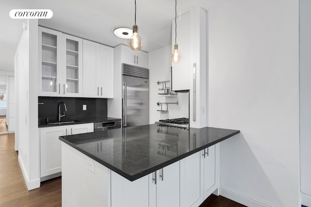 kitchen with appliances with stainless steel finishes, white cabinetry, decorative light fixtures, and sink