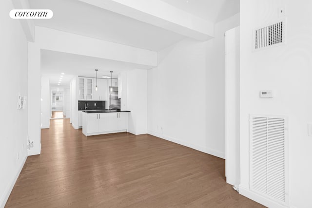 unfurnished living room with dark hardwood / wood-style floors and beamed ceiling