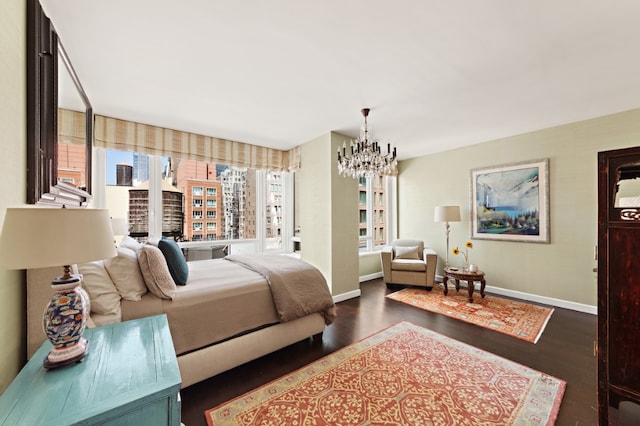 bedroom with wood finished floors, baseboards, and a chandelier