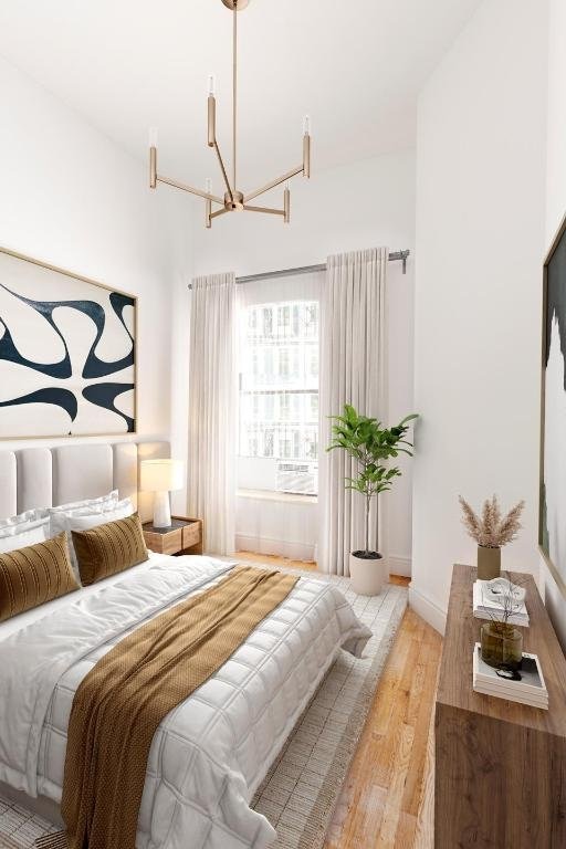 bedroom with a chandelier and light hardwood / wood-style floors