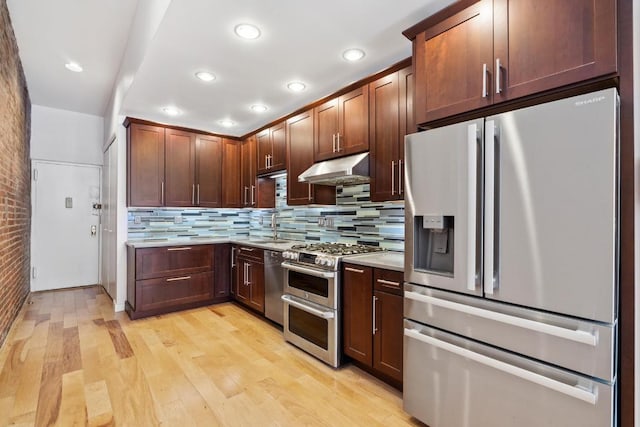 kitchen with decorative backsplash, appliances with stainless steel finishes, sink, and light hardwood / wood-style flooring