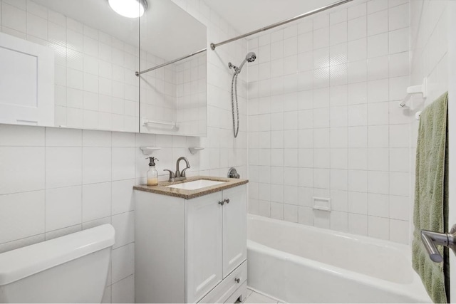 full bathroom with toilet, vanity, tile walls, tiled shower / bath combo, and decorative backsplash