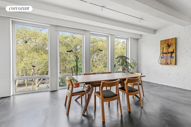 dining room with visible vents, beamed ceiling, finished concrete flooring, and brick wall