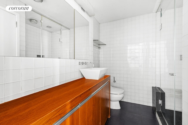 bathroom with toilet, vanity, a shower stall, and tile walls