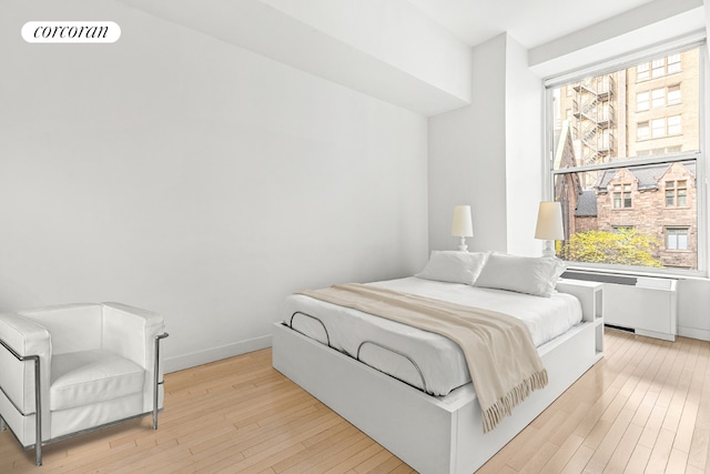 bedroom featuring radiator and light wood-type flooring