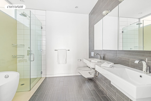 650 6th Ave Unit 2K, New York City, NY 10011 - bathroom featuring baseboards, a freestanding bath, a shower stall, and toilet