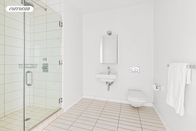 bathroom featuring toilet, tile patterned flooring, and a shower with door