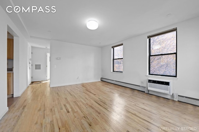 2792 Frederick Douglass Blvd Unit 2B, New York City, NY 10039 - spare room featuring light wood-style flooring, a baseboard radiator, and a wall mounted air conditioner