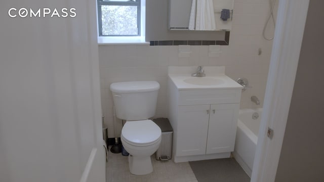 bathroom featuring tile patterned floors, toilet, tile walls, shower / bath combination with curtain, and vanity