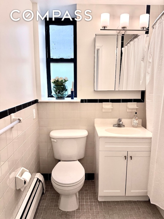 2792 Frederick Douglass Blvd Unit 2B, New York City, NY 10039 - full bath featuring a baseboard radiator, tile walls, vanity, tile patterned flooring, and a wainscoted wall