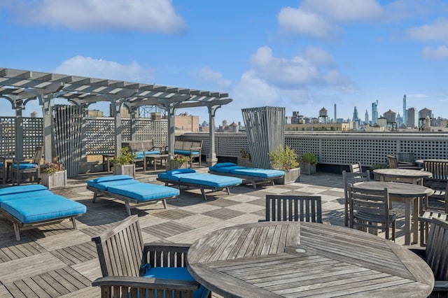 view of patio / terrace featuring a view of city, outdoor dining space, and a pergola