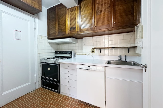 kitchen with dishwasher, range with gas cooktop, light countertops, under cabinet range hood, and a sink