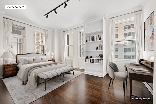 bedroom with dark wood-style floors, visible vents, crown molding, and rail lighting