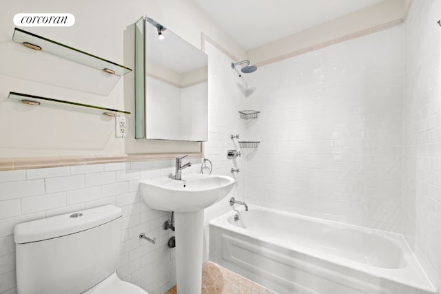 bathroom with shower / washtub combination, tile walls, and toilet