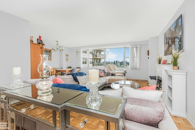 living room with light parquet floors and a notable chandelier