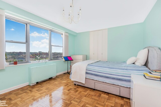 bedroom featuring an inviting chandelier, radiator heating unit, and baseboards